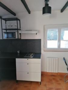 - une cuisine avec un comptoir noir et une cuisinière dans l'établissement Maisonnette indépendante, à Morangis