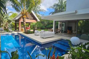 a swimming pool in front of a house at Villa golf de Montchoisy in Mont Choisy