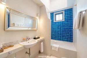 a white bathroom with a sink and a mirror at At Niman in Chiang Mai
