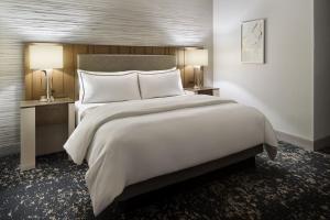 a bedroom with a large white bed and two lamps at The Westin Memphis Beale Street in Memphis