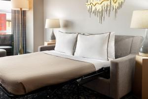 a bed in a room with a couch and a chandelier at The Westin Memphis Beale Street in Memphis