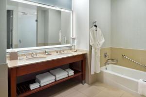 a bathroom with a sink and a tub and a mirror at The Westin Memphis Beale Street in Memphis
