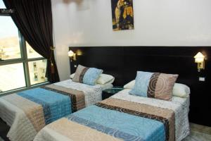 una camera con due letti e una finestra di Aswan Plaza - Share Apartment a Aswan