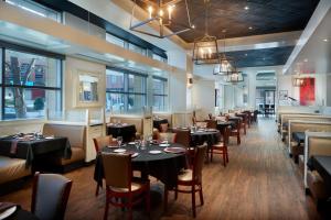 uma sala de jantar com mesas, cadeiras e janelas em The Westin Memphis Beale Street em Memphis