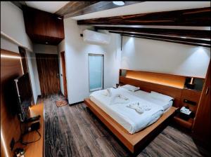 a bedroom with a large bed and a television at Deep Hotel in Mussoorie