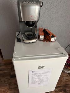 una macchinetta del caffè seduta sopra un frigorifero di Colț de rai - camera de inchiriat a Reşiţa