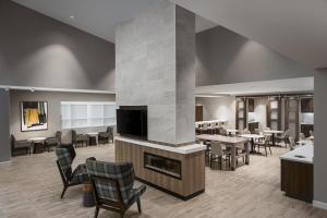 eine Lobby mit einem Kamin sowie Tischen und Stühlen in der Unterkunft Residence Inn by Marriott Denver Aurora in Aurora