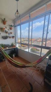 eine Hängematte in einem Zimmer mit einem großen Fenster in der Unterkunft *Apê charmoso com vista do mar in Capão da Canoa