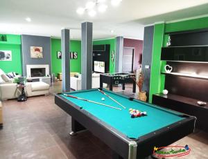 a pool table in a living room with green walls at Relax nel verde in Bracciano