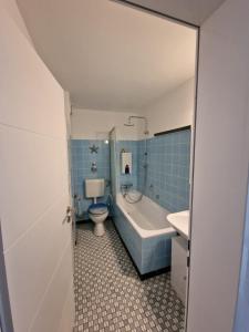 een badkamer met een bad, een toilet en een wastafel bij Ferienwohnung Dornumersiel Nordseeglück am Siel 2024 renoviert in Dornum