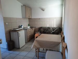 a small kitchen with a table and a table and chairs at Apartmani na moru in Bar