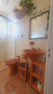 ein Badezimmer mit einem Waschbecken, einem WC und einem Spiegel in der Unterkunft *Apê charmoso com vista do mar in Capão da Canoa