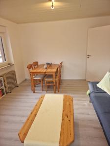 een woonkamer met een houten tafel en een bank bij Ferienwohnung Dornumersiel Nordseeglück am Siel 2024 renoviert in Dornum