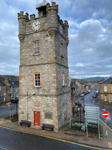 a building with a clock tower on a street at Lyngarrie in Dufftown