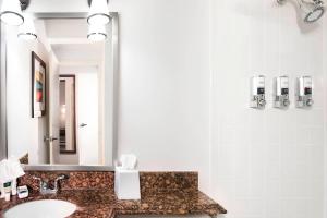 a bathroom with a sink and a mirror at Four Points by Sheraton Kansas City Airport in Kansas City