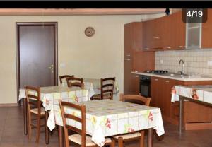 a kitchen with tables and chairs and a kitchen with a stove at B&B Su Neulagi in Triei