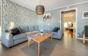 sala de estar con sofá azul y mesa en Cozy Home In Gislaved With Wifi, en Hornbetan