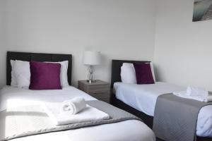 ein Hotelzimmer mit 2 Betten und Handtüchern darauf in der Unterkunft Greenfield House in Norwich
