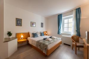 a bedroom with a bed and a desk and a window at Villa Fontana in Trogir