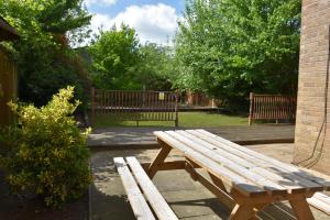 a wooden bench sitting next to a brick building at Greenfield House in Norwich