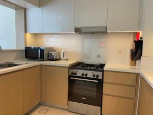 a kitchen with a stove and a microwave at ASHRI HH, Luxurious Apt in Creek in Dubai
