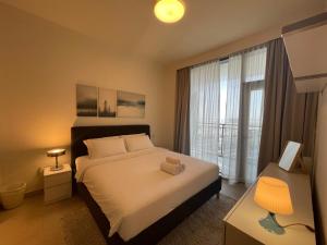 1 dormitorio con cama y ventana grande en ASHRI HH, Luxurious Apt in Creek, en Dubái
