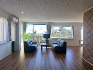 a living room with two couches and a television at E Komo Mai 101号室 in Natsumi