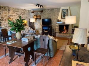 a living room with a table and a fireplace at LOS CARBAYINOS in Villaviciosa