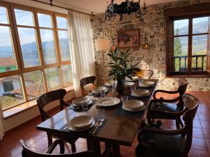 a dining room with a table and chairs and windows at LOS CARBAYINOS in Villaviciosa