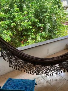 a hammock in front of a window with a tree at Charme do Poço in Recife