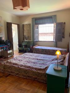1 dormitorio con 2 camas y mesa con lámpara en Charme do Poço, en Recife
