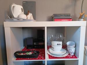a white shelf with wine glasses and books at Pod Małą Sową in Walim