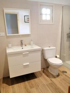 a bathroom with a toilet and a sink and a mirror at Casa Belén in Pozo Negro