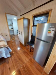 Cette chambre comprend un grand réfrigérateur en acier inoxydable. dans l'établissement Cabaña Loft Curaco de Vélez, à Curaco de Velez