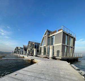 a building on a dock next to the water at schwimmendes Ferienhaus Silent in Elsterheide