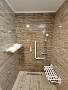 La salle de bains est pourvue d'une douche et de carrelage en bois. dans l'établissement Panorama Boutique Hotel, à Sfântu-Gheorghe