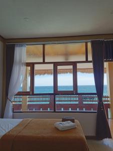 a bedroom with a window with a view of the ocean at Villa Redemptorist in Weetebula