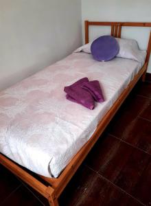 un letto con lenzuola bianche e cuscini viola di Mi Parchita a Valverde