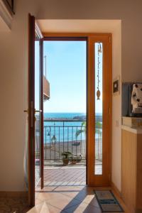 a door leading to a balcony with a view of the ocean at Casa vacanze "Il Baffo e il Mare" in Cetara