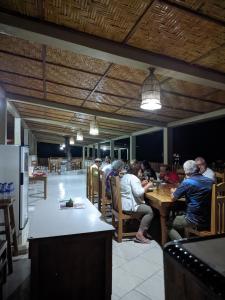 eine Gruppe von Menschen, die an einem Tisch in einem Restaurant sitzen in der Unterkunft Villa Redemptorist in Weetebula