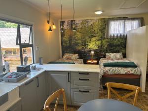 cocina con fregadero y mesa con sillas en Green Cottage en Haenertsburg