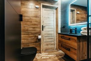 a bathroom with a toilet and a sink and a mirror at Happy Time - Happy Apartamenty Mielec in Mielec
