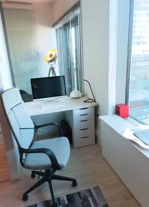 Cette chambre comprend un bureau avec un ordinateur et une chaise. dans l'établissement Modern skyscraper apartment by metro and sea Helsinki, à Helsinki