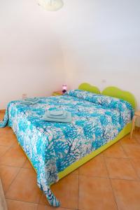 a bed in a room with a blue blanket on it at Casa vacanze "Il Baffo e il Mare" in Cetara