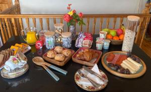 una mesa cubierta con diferentes tipos de alimentos para el desayuno en The Hazel Tree BnB, 