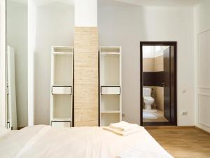 a bedroom with a white bed and a mirror at Gala Apartment Athenaeum - Amazing Arhitecture in Bucharest