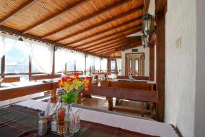 a dining room with a table with flowers on it at Family Hotel Flora in Zlatograd