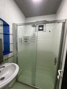 a bathroom with a glass shower and a sink at Guest house Chehra in Samarkand