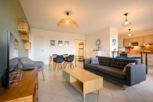 a living room with a couch and a table at Le Capeyron - Parking - WIFI - Aéroport in Mérignac