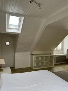 ein Schlafzimmer mit einem weißen Bett und einem Fenster in der Unterkunft Gîte du Port in Ploubazlanec